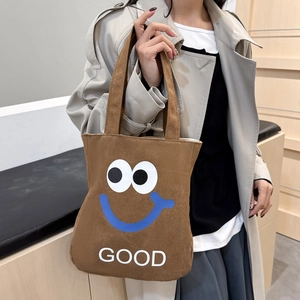 Brown canvas tote bag with cartoon eyes and GOOD text print for students daily use