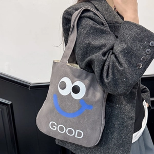 Minimalist grey canvas tote bag with cartoon illustration and GOOD text on model