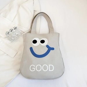 Detail of canvas tote bag with blue smiley face print and sturdy shoulder straps