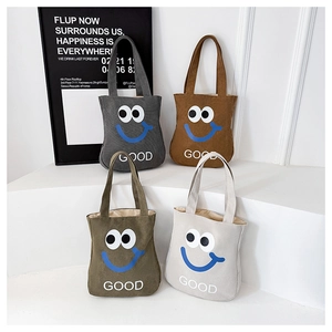 Canvas tote bags in four colors featuring a blue smiley face and GOOD letter print