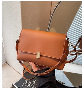 Detailed shot of a caramel brown baguette bag with a golden rectangular metal clasp