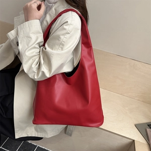 Grande borsa shopper da donna in pelle rossa con design minimalista indossata a spalla