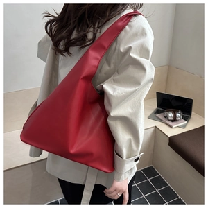 Close-up of red matte leather tote bag featuring a geometric triangle design and wide strap