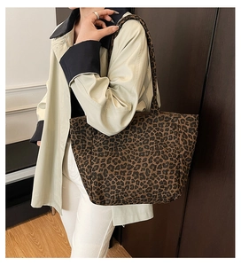 Detail view of large leopard print canvas tote bag on model for casual styling