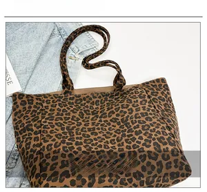 Detailed close-up of the leopard print texture and woven fabric on the tote bag