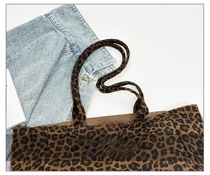 Detail of leopard print tote bag featuring reinforced canvas straps and stylish texture