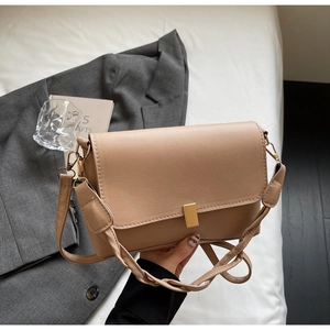 Detail of khaki leather rectangular bag with gold buckle and woven textured strap