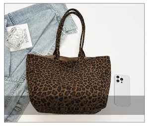 Detail showing large capacity leopard print tote bag with a smartphone for size reference