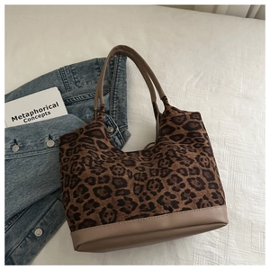 Detail of leopard print tote bag with brown PU leather handles and reinforced base