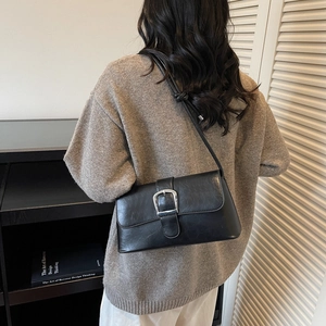 Retro black leather baguette shoulder bag with a silver square buckle on a model