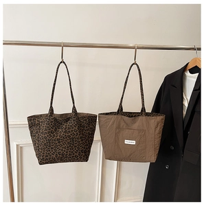 Leopard print and solid coffee tote bags hanging on a display rack for daily style