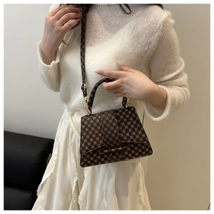 Detailed view of brown geometric print crossbody bag with gold-tone hardware
