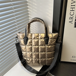 Quilted metallic gold tote bag with black handles and adjustable wide strap