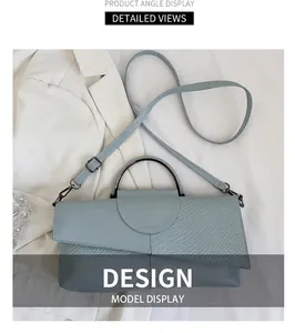 Detail of light blue handbag featuring asymmetric flap with snake pattern and metal handle