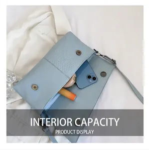 Detail showing the internal capacity of the light blue faux leather crossbody bag