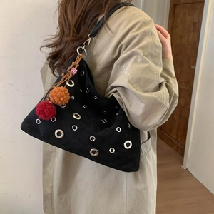 Retro black suede bucket bag with silver grommets and colorful pompom charms