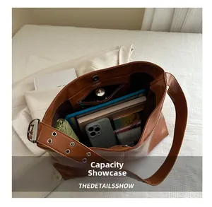 Detail view of the spacious interior with multiple items in the brown patent leather tote