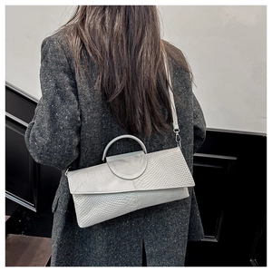 Close-up of light gray crossbody bag with snake-pattern leather and metallic handle