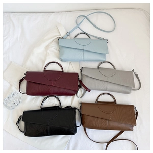 Detalle de bolsos con textura en cinco colores y asas metálicas de diseño elegante