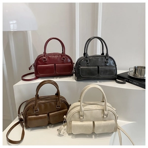 Close-up of retro leather handbags in four colors displayed on studio steps