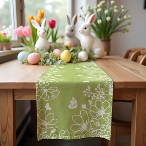 Detail of green linen table runner with white floral and butterfly patterns for Easter