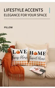 Detail of two autumn pillows with LOVE and HOME prints on a cozy sofa with blanket