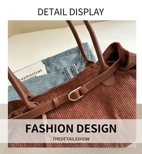 Close-up of brown corduroy tote bag with leather straps and gold metal hardware