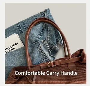 Detail of brown corduroy tote bag featuring leather handles and metal buckle accents