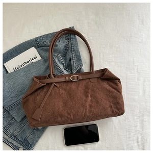 Detailed view of dark brown corduroy tote bag with leather straps and retro texture