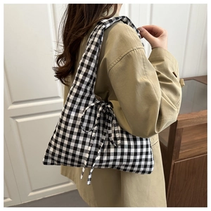 Detail view of the black and white gingham shoulder bag with a side bow ribbon decoration
