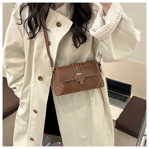 Vue détaillée du sac en cuir marron avec surpiqûres blanches et boucle métal