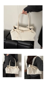 Detail of off-white corduroy tote bag featuring striped texture and metallic buckle strap