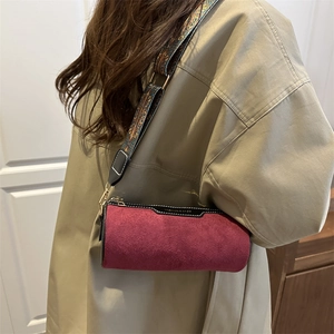 Borsa a tracolla a cilindro in camoscio bordeaux con cinturino largo e finiture metalliche