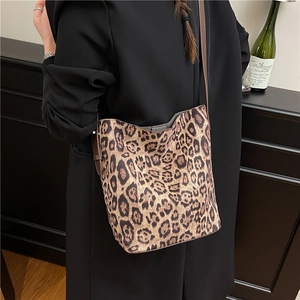 Vintage leopard print suede bucket bag with adjustable strap worn by model in a black suit