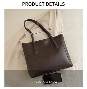 Detailed view of coffee brown tote bag showing size comparison with a smartphone