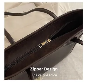 Detail view of the secure gold zipper closure and striped lining on the brown tote bag