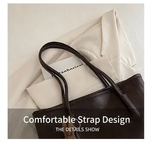 Close-up of the reinforced shoulder strap stitching and lychee texture on the tote