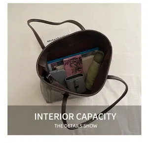 Top view of spacious brown leather tote bag interior with everyday essentials like a tablet