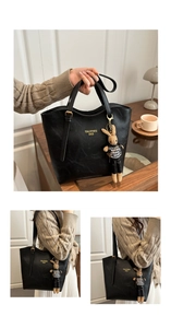 Detail of black faux leather tote bag with gold logo and plush rabbit pendant charm