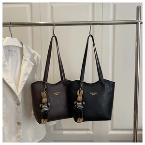 Close-up of leather tote bags with gold logo and stylish houndstooth bunny charms