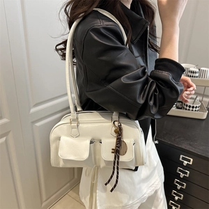 Sac boston chic en cuir crème avec doubles poches avant et breloque clé vintage