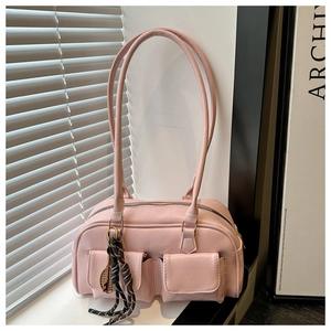 Détail d'un sac à main rose avec doubles poches frontales et pendentif raquette de tennis