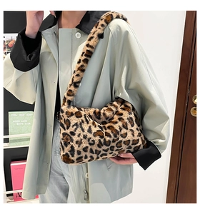 Side view of faux fur leopard print shoulder bag worn by model in casual street style