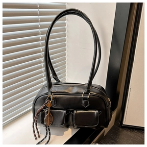 Détail d'un sac à bandoulière en PU noir avec deux poches et pendentif raquette de tennis