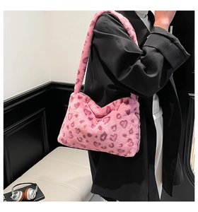 Close-up of pink plush underarm bag with heart leopard print on a female model