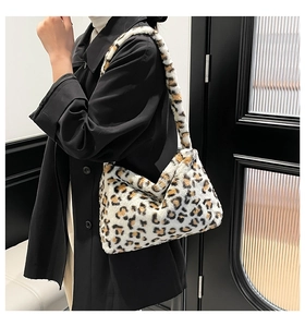 Close-up of fluffy leopard print faux fur shoulder bag worn by model in minimalist setting