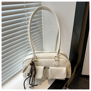 Vue détaillée du sac à bandoulière en similicuir blanc avec doubles poches et pendentif feuille