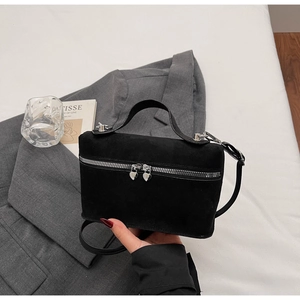 Detail of black suede mini bag featuring silver heart-shaped double zippers and handle