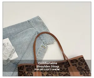 Detail view of the leopard print tote bag featuring sturdy brown straps and stitching