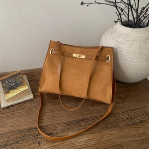 Sac bandoulière minimaliste en daim marron avec fermoir tournant doré sur bois